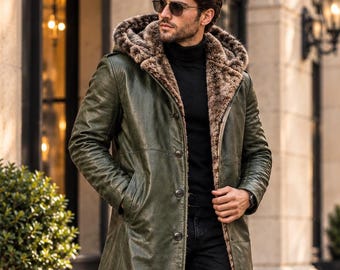 May include: A long olive green leather coat featuring a large hood lined with brown faux fur, a button-front closure, and long sleeves. The coat is worn over a black turtleneck sweater and black trousers, paired with dark sunglasses.