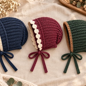 May include: Three crocheted bonnets in navy blue, burgundy, and dark green. Each bonnet features a ribbed texture, a scalloped or straight contrasting trim along the face opening, and matching crocheted chin ties for securing the headwear.