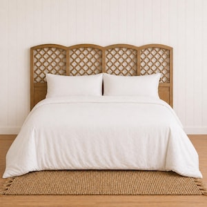 May include: A bedroom set featuring a wooden headboard with a lattice design, two white pillows, and a white duvet cover. A woven jute rug sits at the foot of the bed. The headboard is approximately 72 inches wide.