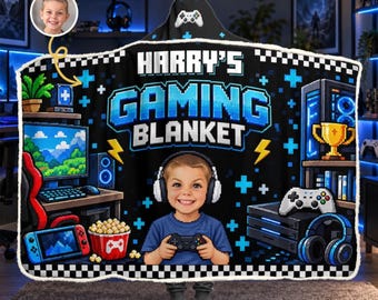 Puede incluir: Una manta con capucha negra con un tema de juego pixelado y el texto HARRY'S GAMING BLANKET. El diseño incluye a un niño con auriculares, un monitor de computadora, un mando de juego, un trofeo y un cubo de palomitas.