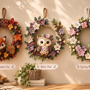 May include: Three circular crochet wreaths hanging on a wall. The left wreath features an orange fox with autumn leaves and acorns. The centre wreath displays an owl surrounded by purple and white flowers. The right wreath shows a white bunny with flowers.