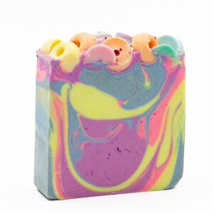 May include: A colorful swirl soap bar with a variety of pastel colors, including pink, yellow, blue, and green. The soap has a decorative design on top with colorful swirls and dots.