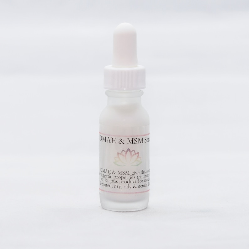 May include: A clear glass bottle with a white dropper and a white label that reads "DMAE & MSM Serum". The label also includes a pink and white lotus flower and text that reads "DMAE & MSM give this serum energetic properties that make it a fabulous product for mature, tinted, dry, oily & acneic skin."
