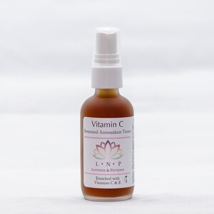 May include: A brown glass bottle with a white spray top. The bottle is labeled "Vitamin C Botanical Antioxidant Toner" and "LNP Lotions & Potions". The label also says "Enriched with Vitamins C & E".