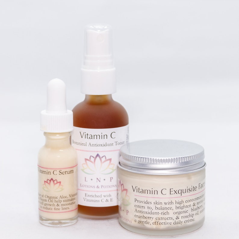 May include: Three glass bottles of Vitamin C skincare products. The bottles are labeled "Vitamin C Botanical Antioxidant Toner", "Vitamin C Serum", and "Vitamin C Exquisite Face Cream". The bottles are on a white background.