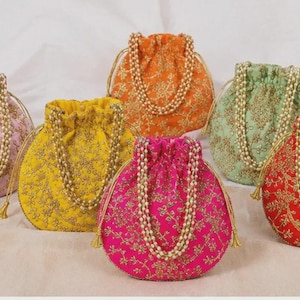 May include: A collection of six round drawstring pouches in pink, yellow, orange, light green, magenta, and red. Each pouch features intricate gold floral embroidery and a handle made of white faux pearls, with gold drawstring cords at the top.