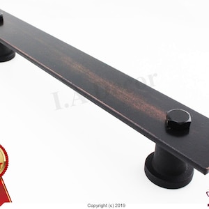 May include: Black metal door pull handle with a distressed finish. The handle is rectangular and has two round mounting plates.  The handle is a best seller.