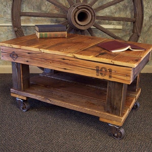 May include: A rustic wooden coffee table with a lower shelf and wheels. The table is made from reclaimed wood and has a natural wood finish. The table has a distressed look and is perfect for a farmhouse or industrial style home.