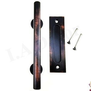 May include: A rustic, bronze-finished barn door handle set. The set includes a long, cylindrical pull handle, a recessed finger pull, and two silver screws. The handle is approximately 12 inches long.