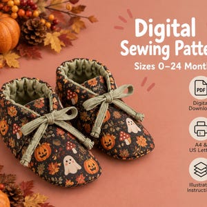 Puede incluir: Un par de patucos para bebé de tela negra con estampado de calabazas naranjas, fantasmas blancos, setas rojas y hojas de otoño. Los patucos tienen cordones verde claro y forro verde. Texto: Digital Sewing Pattern Sizes 0-24 Months.