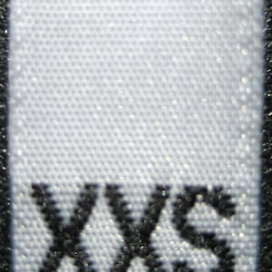 May include: White clothing tag with black text that reads "XXS".