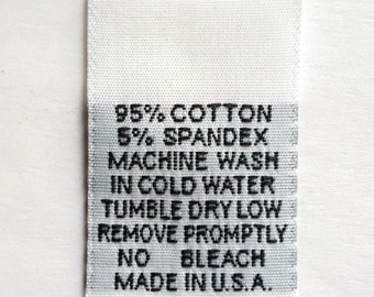 May include: White fabric care label with black text. The label states "95% Cotton 5% Spandex Machine Wash in Cold Water Tumble Dry Low Remove Promptly No Bleach Made in U.S.A."