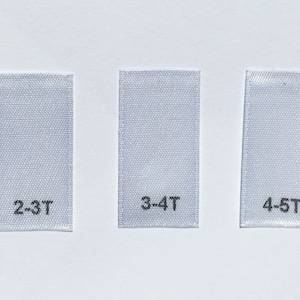 May include: Three white fabric labels with black text indicating different sizes: 2-3T, 3-4T, and 4-5T.