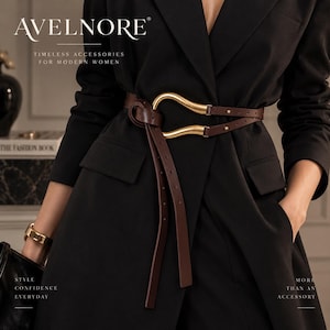 Pode incluir: Um cinto de couro castanho escuro com uma grande fivela de metal dourado em forma de ferradura, usado sobre um blazer preto. O cinto tem um design com nó, duas pontas longas pendentes e pequenos rebites metálicos na tira ajustável.