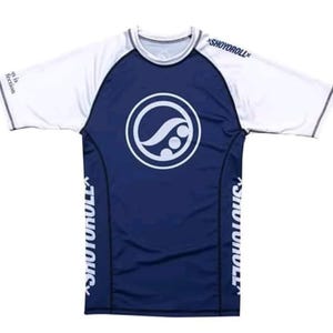 Op de afbeelding: Een sportshirt met korte mouwen, een marineblauwe romp en witte mouwen. Op de borst staat een wit cirkelvormig logo. De tekst SHOYOROLL is verticaal gedrukt langs de zijpanelen en op de linkerschouder van het kledingstuk.