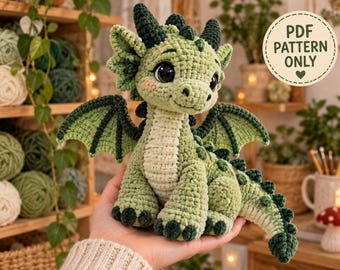 Könnte beinhalten: Ein gehäkeltes grünes Drachen-Plüschtier mit großen schwarzen Augen, einem cremefarbenen Bauch und dunkelgrünen Stacheln entlang des Rückens und Schwanzes. Das Spielzeug hat strukturierte Flügel und ein Lächeln. Ein Etikett zeigt PDF PATTERN ONLY.