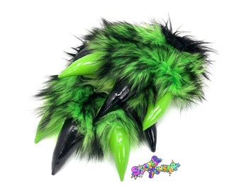 May include: A set of five green and black faux fur tails with black claws. The tails are made of fluffy faux fur and have a shiny black claw tip.