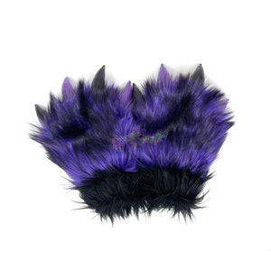 May include: A pair of black and purple furry paw-shaped hand warmers with black claws.