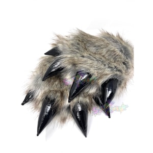 May include: A pair of furry brown and gray wolf paw slippers with black claws. The slippers are made of soft, plush fabric and have a realistic wolf paw design.