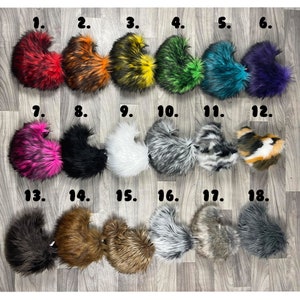 May include: Eighteen faux fur tails in various colors and styles, including black, white, gray, brown, pink, orange, yellow, green, blue, and purple. The tails are numbered 1 through 18.
