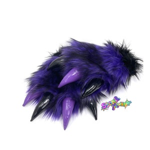 May include: A pair of purple and black faux fur claws with black and purple claws. The claws are made of a soft, plush material and are perfect for adding a touch of whimsy to any costume.