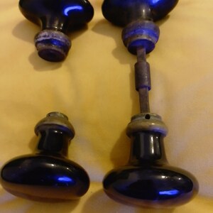 Set of 4 round and olive-shaped black porcelain door knobs with stem