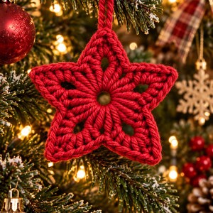 Puede incluir: Un adorno en forma de estrella de cinco puntas hecho de hilo rojo, con una textura de ganchillo con detalles calados y un pequeño centro circular. La estrella incluye un lazo de hilo rojo a juego en la parte superior para colgarla.