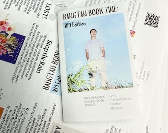 Könnte beinhalten: Ein weißes Zine mit dem Titel Bangtan Book Zine: RM Edition, das ein Foto einer Person in hellem Hemd und Hose zeigt, die in hohem Gras steht. Das Cover enthält den Text: RM x SFMOMA, Oktober 2026, und Lyric Translations by Doolset Bangtan.