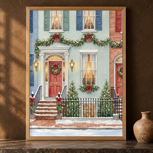 Puede incluir: Una impresión artística enmarcada que representa la fachada de una casa adosada de color azul claro en invierno. La escena incluye puertas rojas, guirlandas verdes con lazos rojos, escalones cubiertos de nieve y ventanas iluminadas.