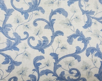 5th Avenue Designs for Covington decorator fabric. Cream background with blue scrolls and pale green leaves. Drapery weight