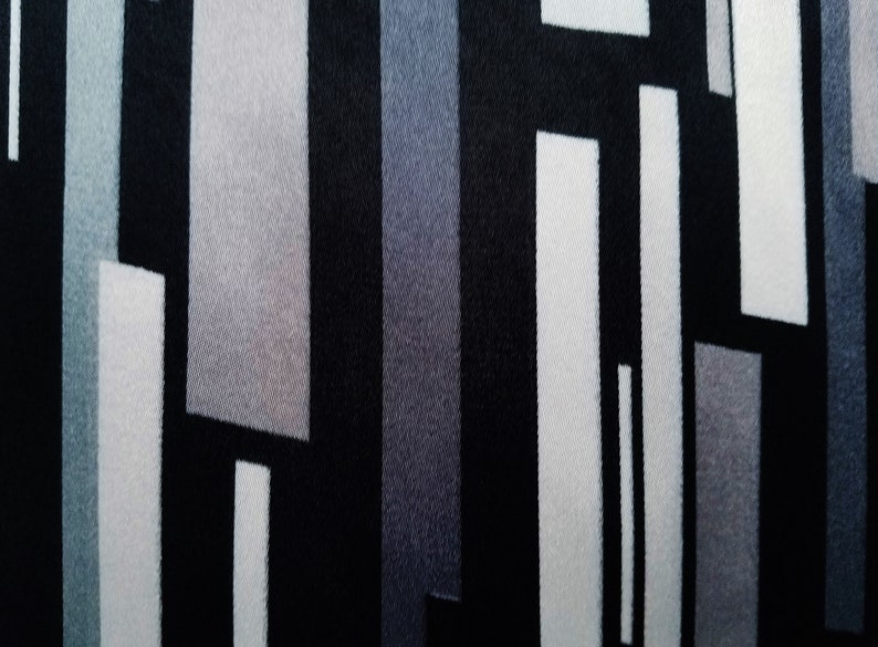 May include: Abstract geometric pattern fabric with black, white, and gray stripes and rectangles.