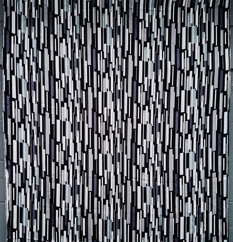 May include: Black and white fabric with a geometric pattern of vertical lines and rectangles. The fabric has a subtle sheen and a smooth texture.