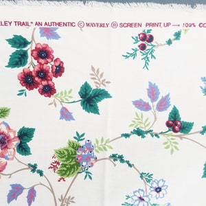 May include: White fabric with a floral pattern featuring pink, red, and blue flowers with green leaves. The fabric has the text "Valley Trail" "An Authentic" "Waverly" "Screen Print, Up" "100% Cotton" printed on it.