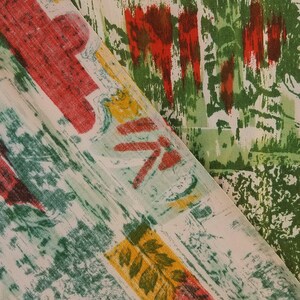 Pu&ograve; includere: Due pezzi di tessuto con motivi astratti in tonalit&agrave; di verde, rosso e giallo. Il tessuto &egrave; piegato, mostrando entrambi i lati del materiale.