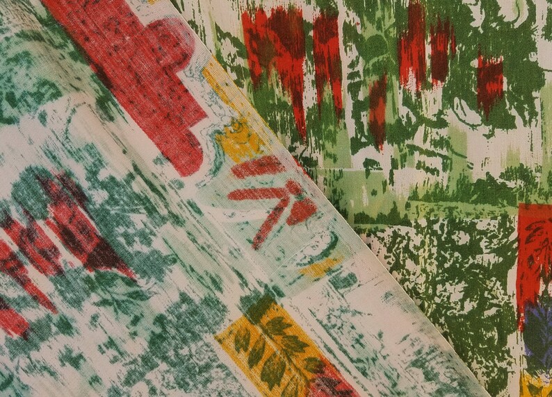 Pu&ograve; includere: Due pezzi di tessuto con motivi astratti in tonalit&agrave; di verde, rosso e giallo. Il tessuto &egrave; piegato, mostrando entrambi i lati del materiale.