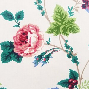 May include: A white background with a pink rose, green leaves, and brown branches. The rose has a red center and is surrounded by smaller blue flowers.