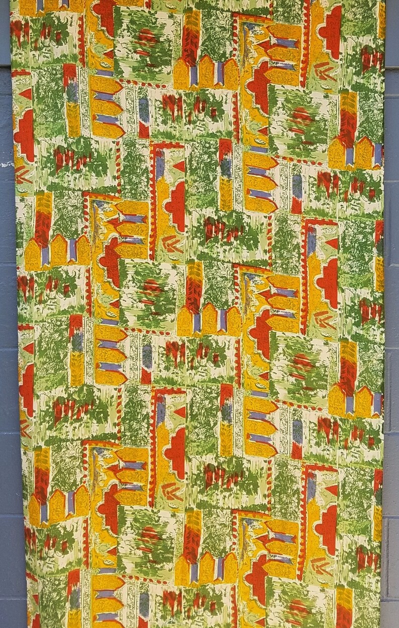 Pu&ograve; includere: Un tessuto con un motivo ripetitivo di forme geometriche in tonalit&agrave; di verde, giallo, rosso e blu. Il motivo ricorda un design tessile tradizionale.