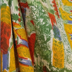 Pu&ograve; includere: Un tessuto colorato con un motivo ripetitivo di verde, giallo, rosso e blu. Il tessuto ha un design testurizzato, come pennellate.