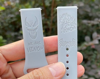 May include: Two gray silicone watch bands with a Venom design. One band has the text "We are Venom" and the other has a Venom character graphic.