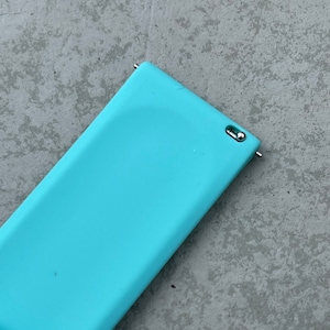 May include: A light blue silicone watch band with a silver metal connector.