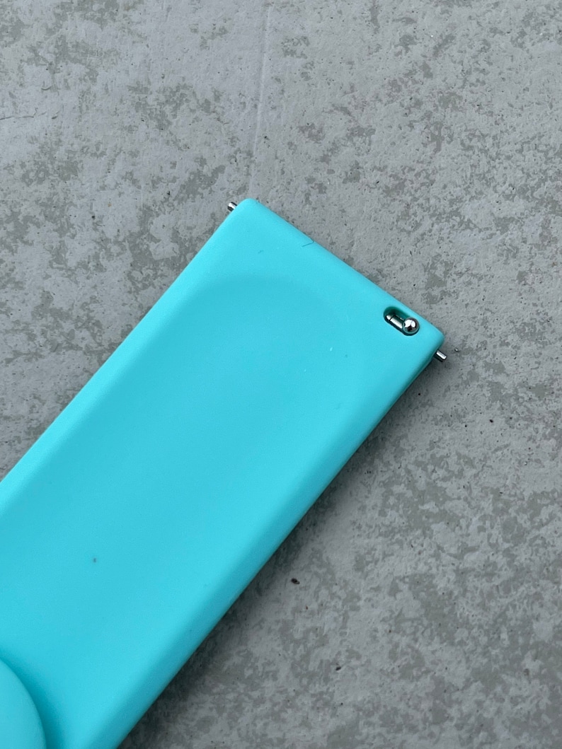 May include: A light blue silicone watch band with a silver metal connector.