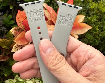 May include: Two gray Apple Watch bands with the text "This is the way" and a Mandalorian symbol.