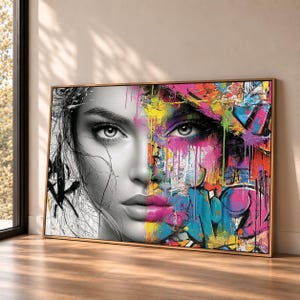 May include: A rectangular wall art print featuring a split-face portrait. The left side is a black and white sketch of a face, while the right side is a vibrant, multi-coloured graffiti-style composition with drips of pink, yellow, and blue paint.