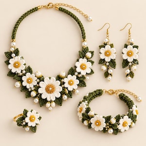 May include: A jewelry set featuring a necklace, a bracelet, a ring, and two drop earrings. Each piece is crafted with dark green crocheted leaves, white crocheted daisy flowers with yellow centers, and small white faux pearls on gold-tone metal.