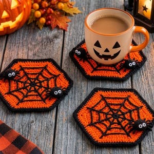 May include: Three hexagonal crochet coasters featuring a vibrant orange background with a black spiderweb pattern. Each coaster is adorned with small black pom-pom spiders that have white googly eyes attached to the web design.
