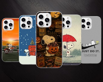 May include: Five smartphone cases featuring Snoopy illustrations. Designs include Snoopy on a motorcycle at sunset, decorating a Christmas tree, holding a pumpkin for Halloween, standing under a red umbrella in the rain, and lying on a Nike swoosh logo.