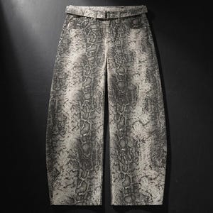 May include: High-waisted trousers featuring a grey and black snakeskin print pattern. The trousers include a matching fabric belt with a rectangular buckle, two front pockets, and a wide-leg silhouette that tapers slightly towards the hem.
