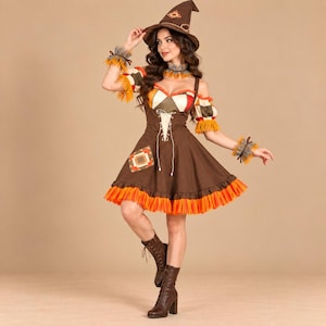 May include: A brown dress with a lace-up bodice, off-the-shoulder sleeves, and a skirt featuring a bright orange ruffled hem. The outfit includes a matching brown pointed hat, a neck ruffle, and wrist cuffs, all accented with straw-like fringe.