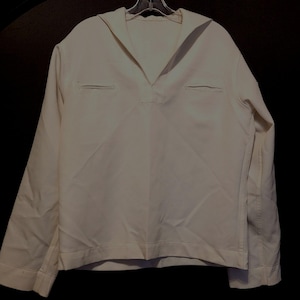 May include: A white long-sleeved shirt with a sailor collar. The shirt has two pockets on the chest.