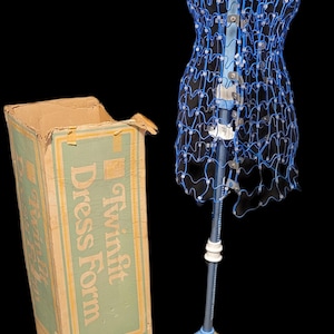 Puede incluir: Una taza de cerámica blanca con un asa negra y el texto "But First, Coffee" en negrita negra. La taza está sobre un fondo borroso, sugiriendo un ambiente acogedor. La taza mide aproximadamente 10 cm de altura.